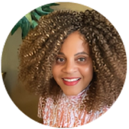 Woman with curly hair smiling warmly.