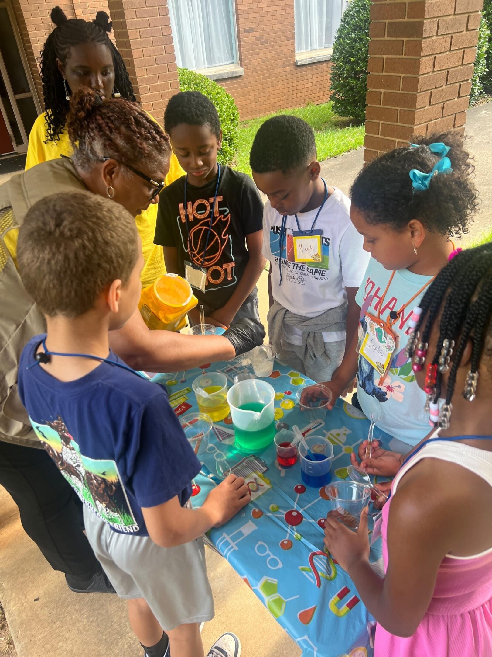 Children engaging in a colorful science experiment outdoors.