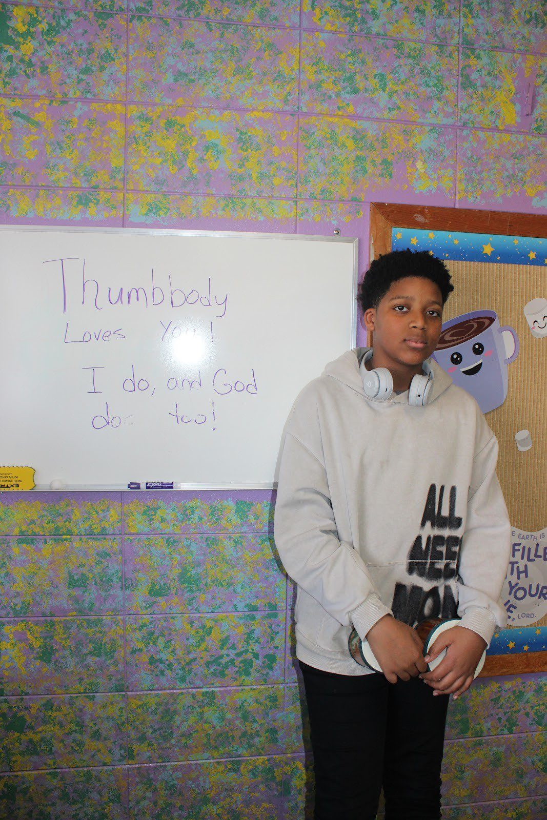 Young man standing in front of a whiteboard with 'Thursdays are for the Lord' written on it.