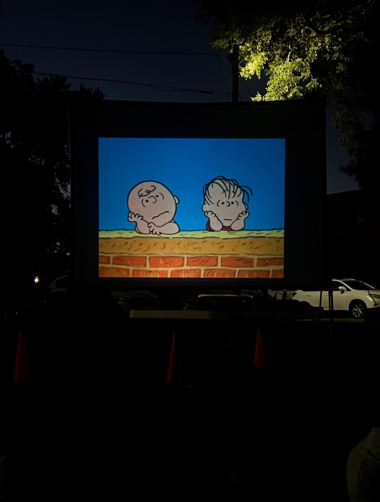 Two cartoon characters appear on a screen against a dark background.