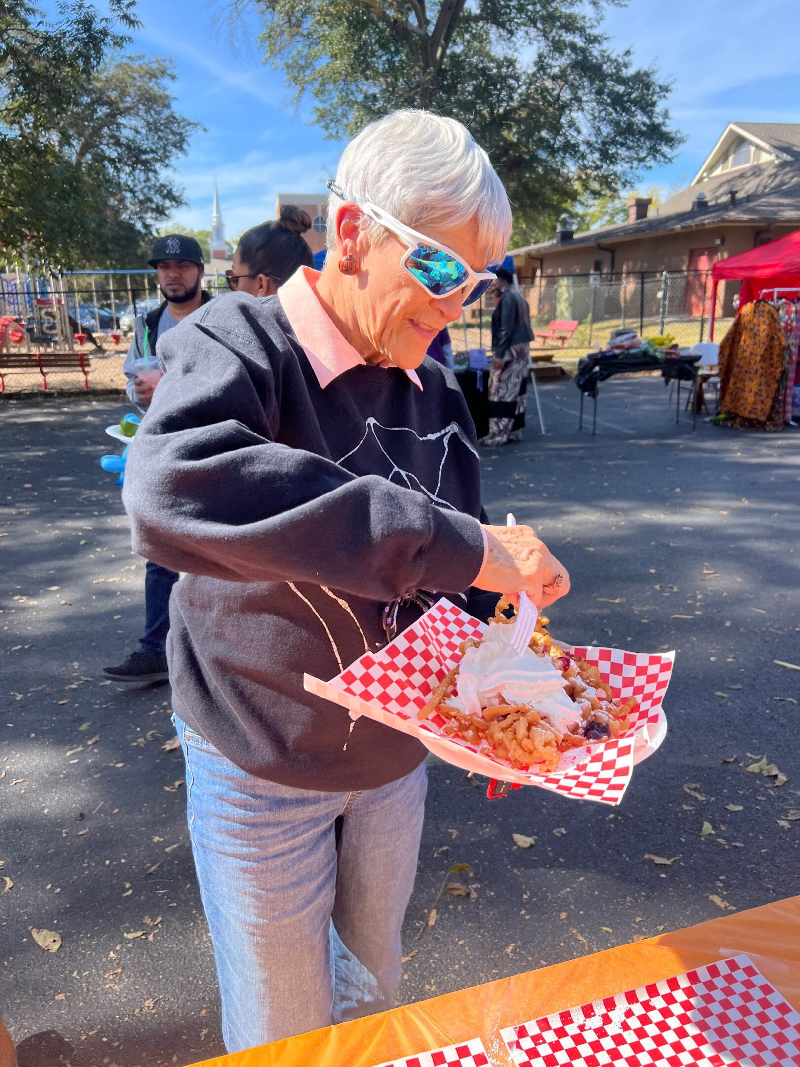 Man enjoys a meal outdoors on a sunny day.