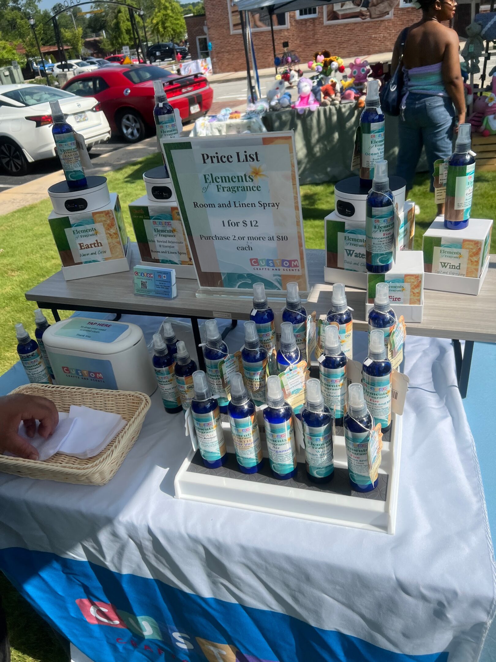 Display of skincare products on a table at an outdoor event.
