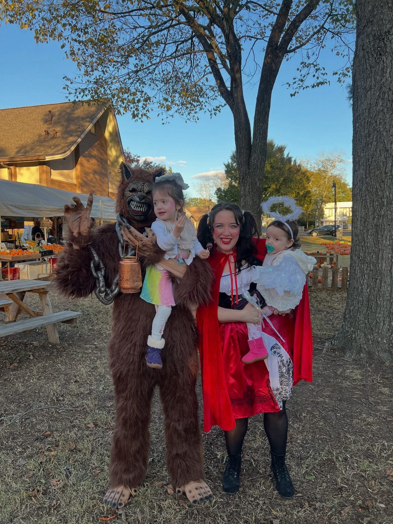 Family dressed in festive costumes outdoors at a fair.