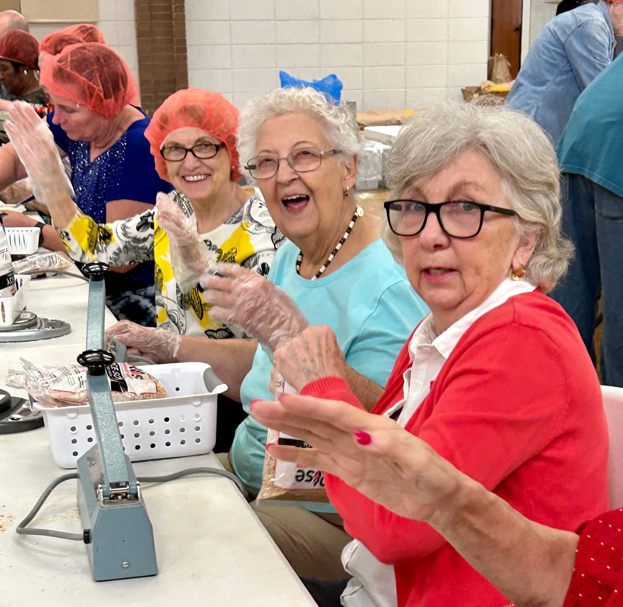 Elderly women enjoying drinks and laughter at a social gathering.